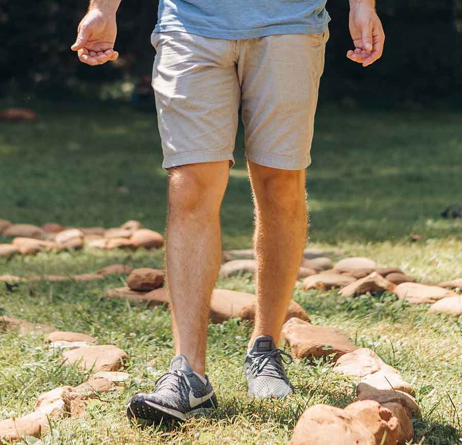 man in shorts walking outside path