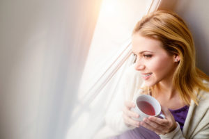 woman smiling drinking tea understanding microbiome and mental health