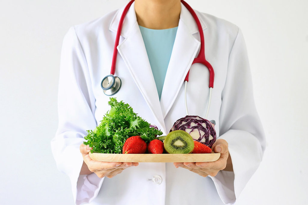 doctor with platter of healthy foods showing how nutrition can help recovery