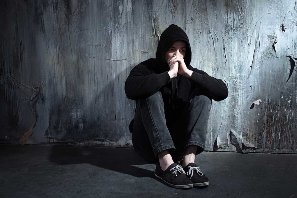 hooded figure sitting against wall mental health disorders and addiction