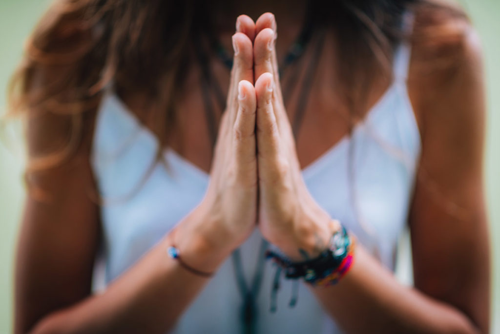 woman with prayer hands using spirituality in recovery