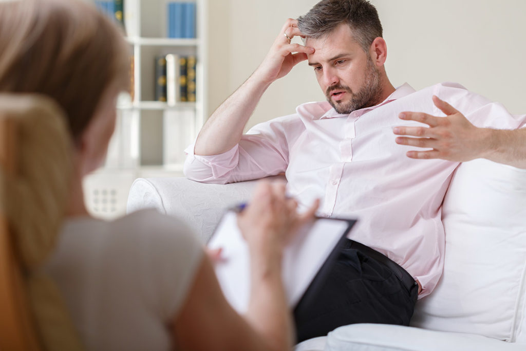 man on couch talking with therapist about What Is Cognitive Behavioral Therapy