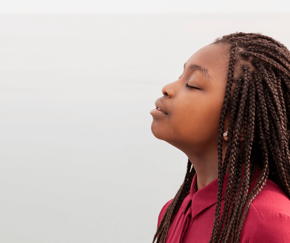 A black woman in a red shirt leans her head back and take a deep breath