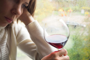 sad woman with wine experiencing alcohol and depression