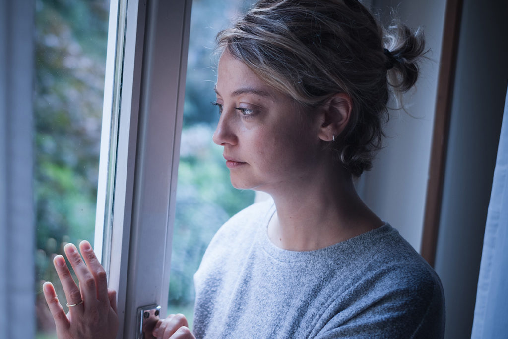 woman staring out of a window wondering am I an alcoholic