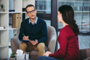 A male therapist speaks with a female client