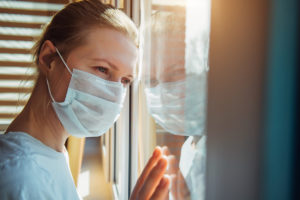 woman looking out window struggling with her eating disorder during the covid-19 pandemic