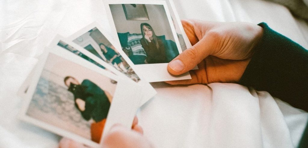 Polaroid photos held out by two hands