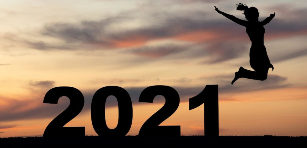 woman jumping over large "2021" at dawn
