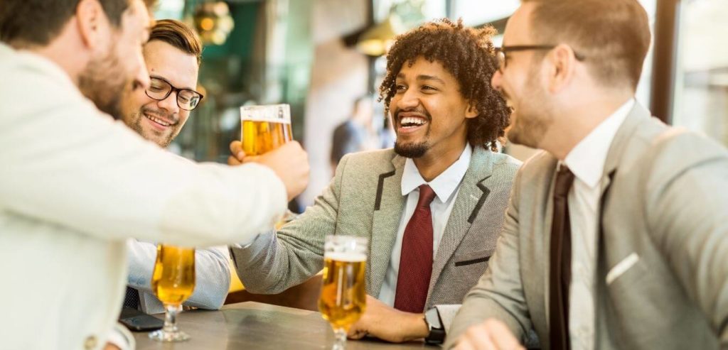 A group of men in suits having beers after work