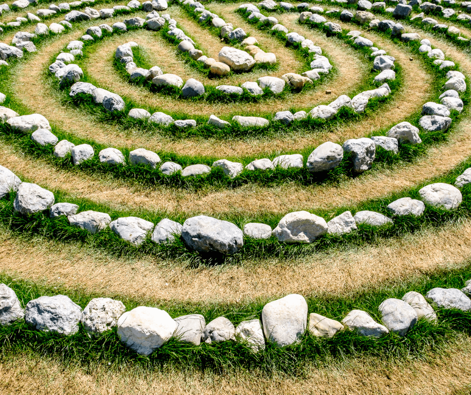 A circular rock labrynth with green grass around the rocks