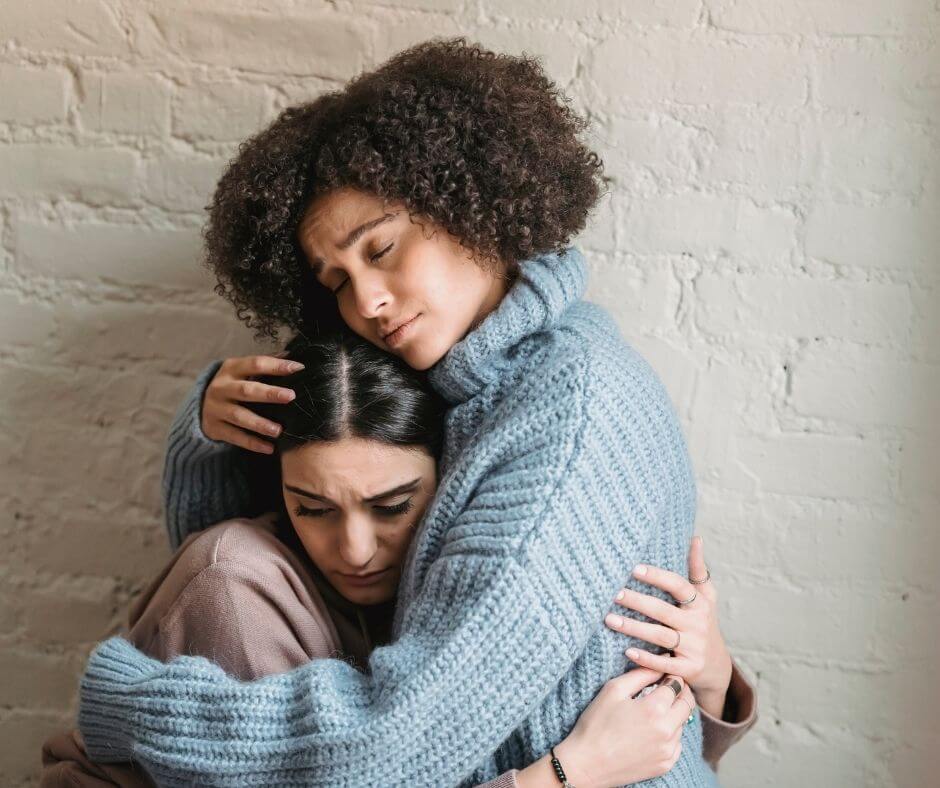 A woman hugging and consoling another woman