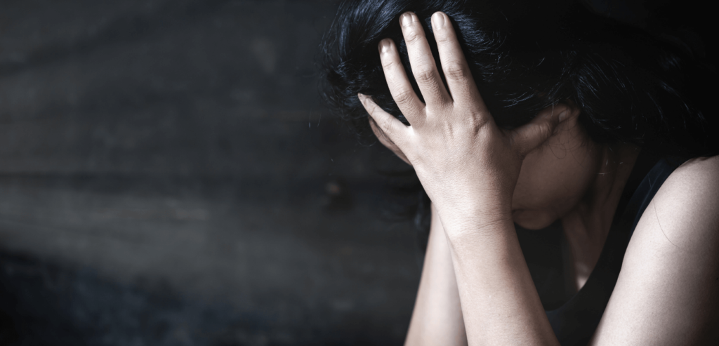 A woman with both hand on her head looking depressed because she was sexually abused