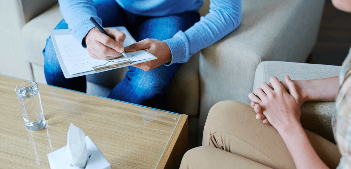 Male psychologist making notes during psychological therapy