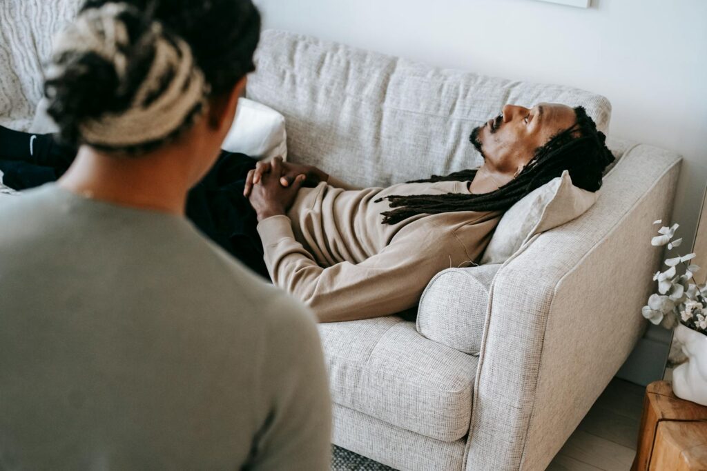 Black man lying on sofa during psychotherapy