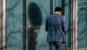 man standing near glass wall, understanding narcissistic personality disorder and alcoholism