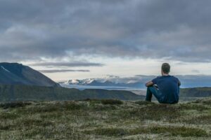 Man on mountain thinking about what causes porn addiction
