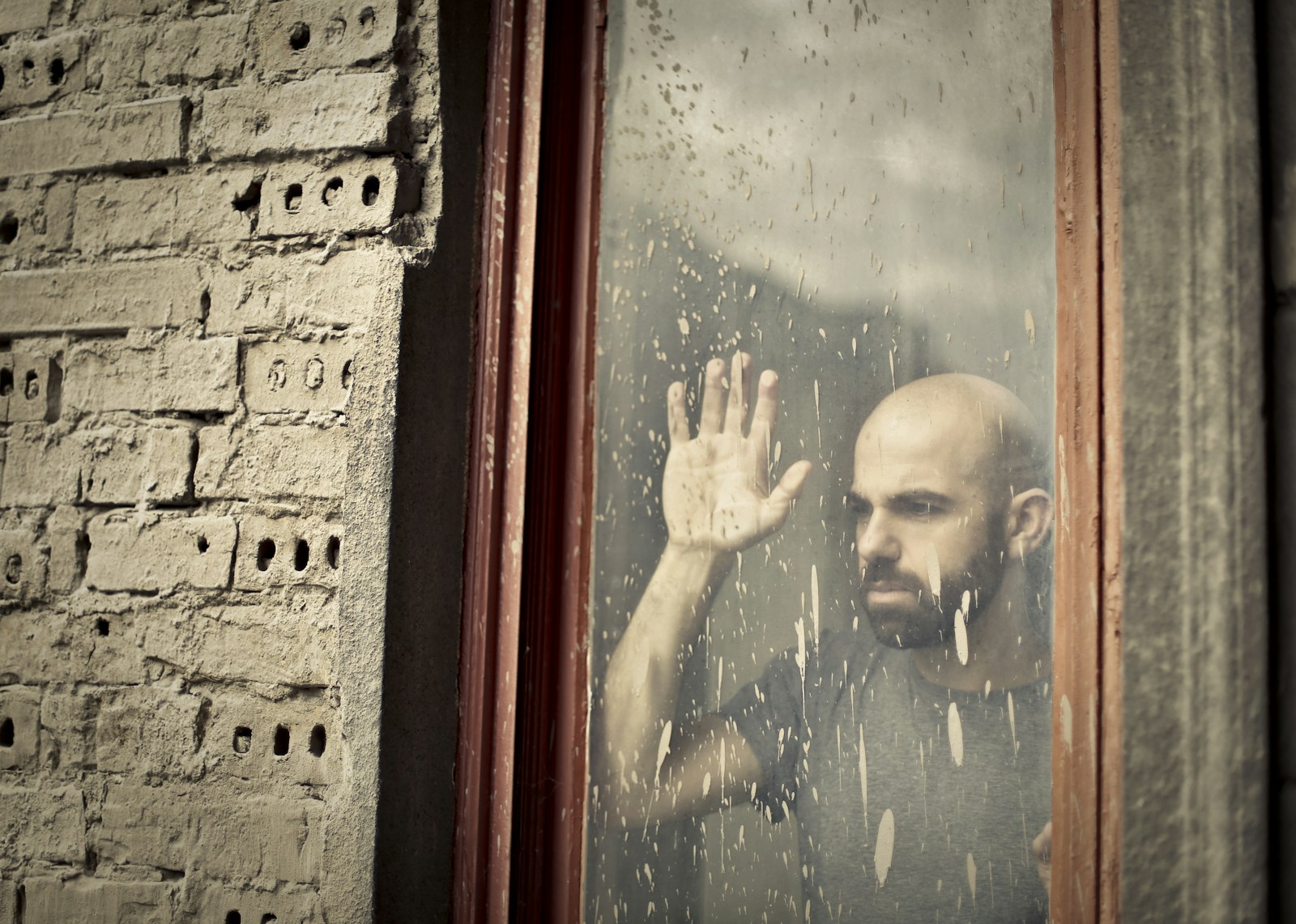 man leaning on window concerned about hypersexuality and trauma