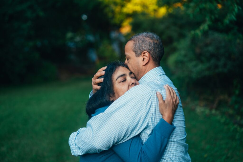 man hugging woman struggling with grief and loss near trees