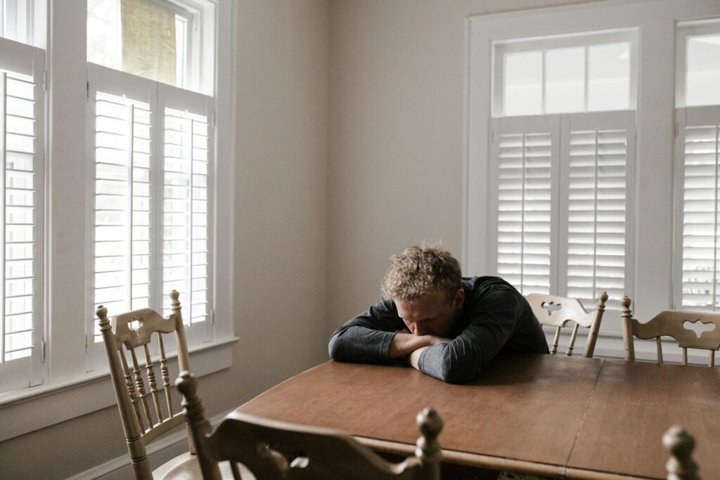 Man sitting at table in need of Men's Residential treatment