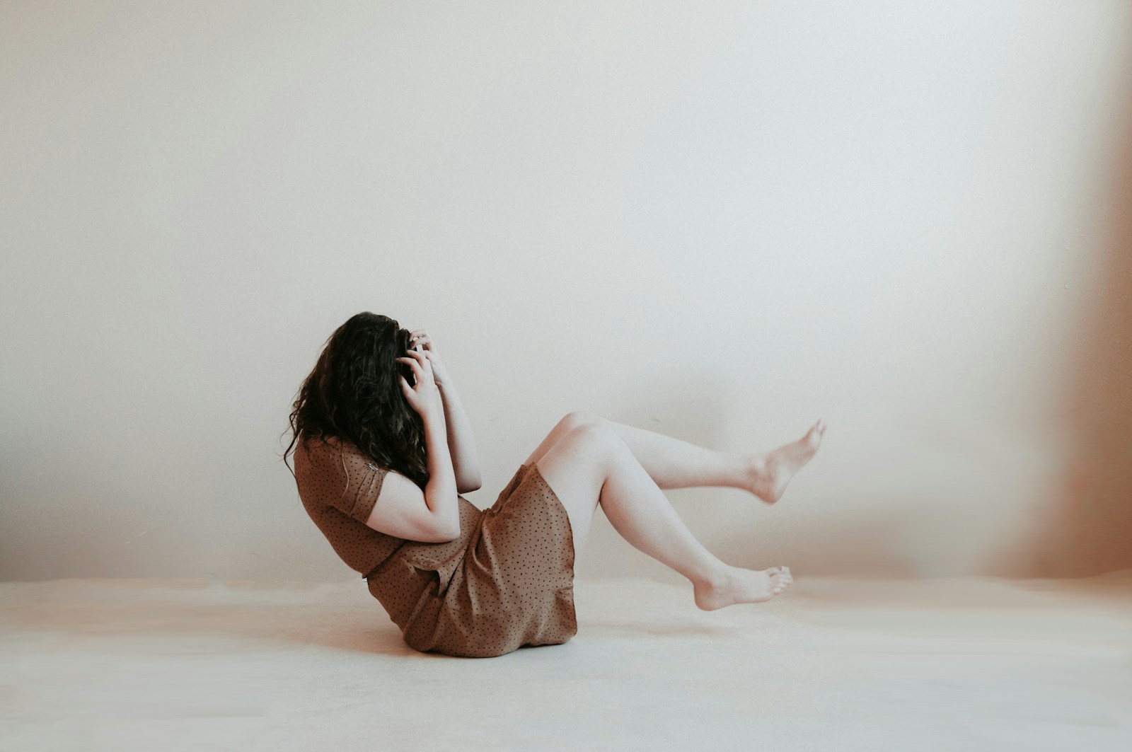 woman sitting on floor wearing brown dress, eating disorder therapist