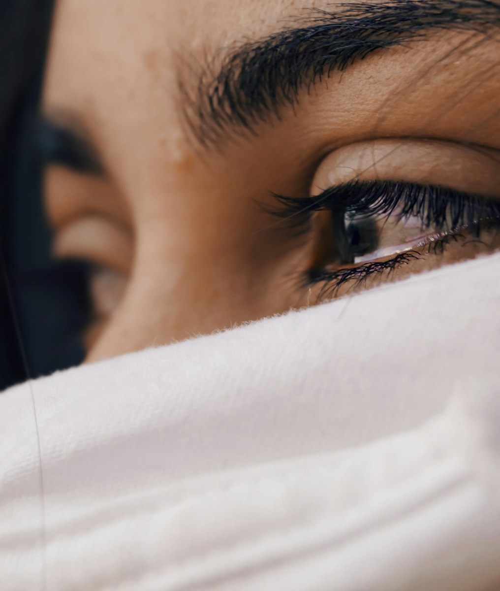 shallow focus of a woman's sad eyes, trauma bonding cycle