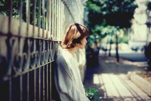 woman leaning against wall thinking about her opioid withdrawal symptoms and timeline