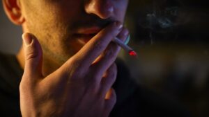 a man smoking a cigarette in the dark, marijuana addiction treatment