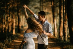 man and woman dancing at center of trees on a journey of healthy sex after sexual sobriety