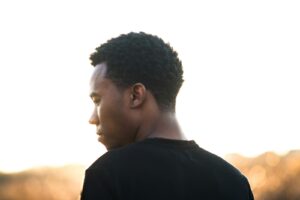 man wearing black crew-neck t-shirt thinking about the types of trauma