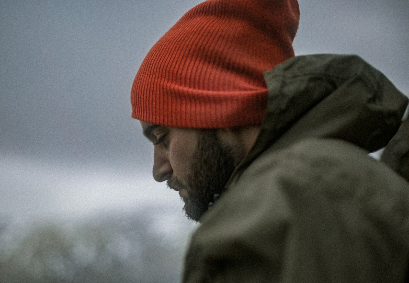 man wearing gray hoodie and orange knit cap thinking about porn addiction statistics