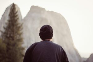 man wearing blue top facing mountain and struggling with fentanyl addiction symptoms