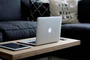 MacBook Air on brown wooden center table, ready for online addiction treatment