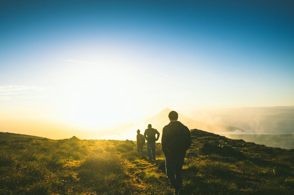 silhouette of three men falling in line while walking during golden hour, discussing how to help someone with a porn addiction