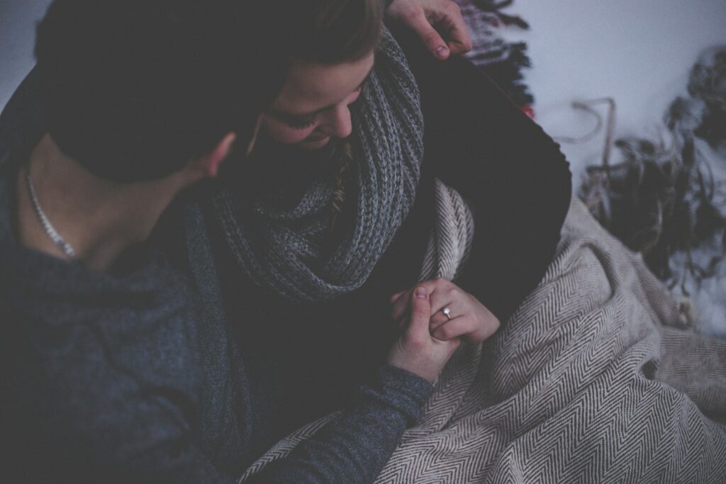 couple with grey blanket wondering, "Is Watching Porn Cheating?"