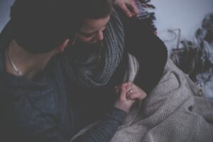 couple with grey blanket wondering, "Is Watching Porn Cheating?"