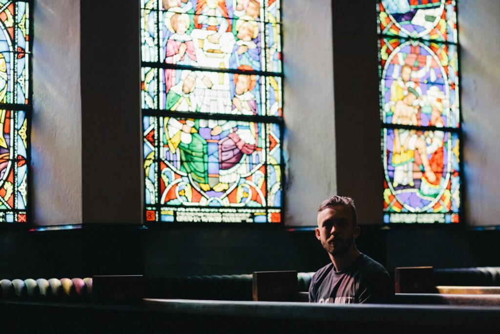 man sitting on pew chair thinking about spirituality in addiction recovery
