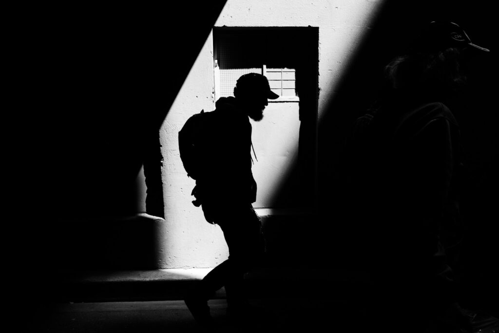person carrying backpack walking on street working on overcoming shame