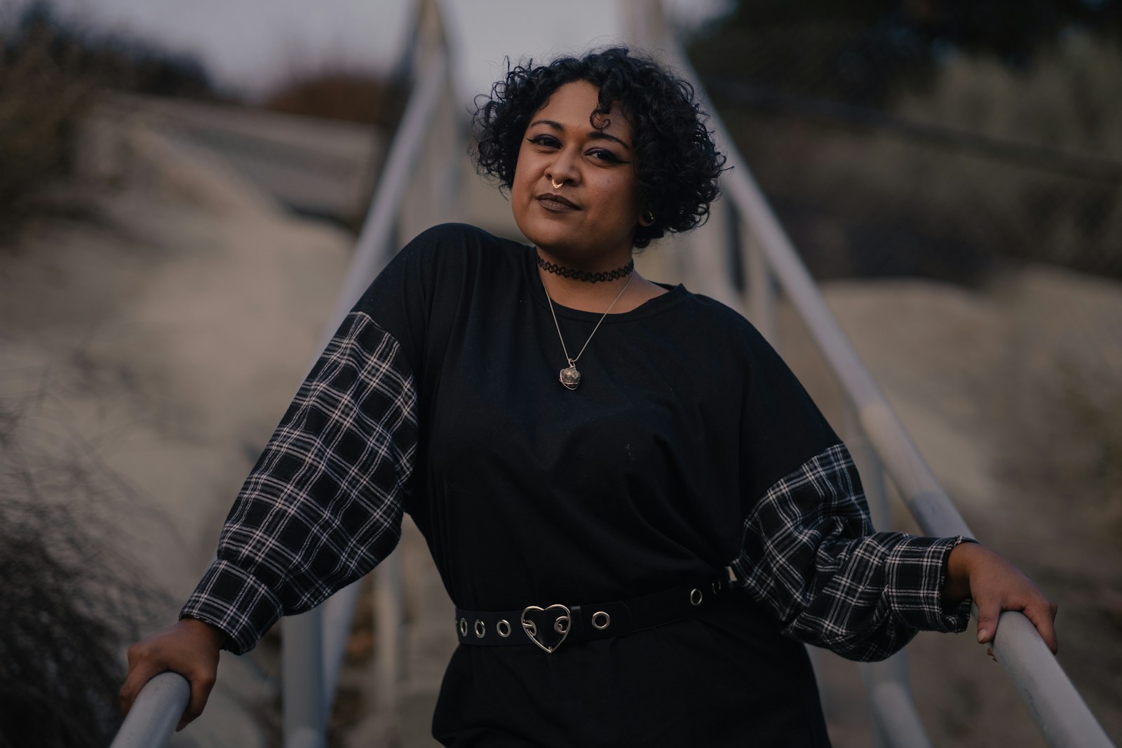 a woman standing on a bridge with her arms crossed, learning self-forgiveness