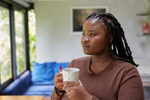 a person holding a cup, thinking about self sabotaging behavior