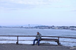 Man struggling with social isolation on a bench