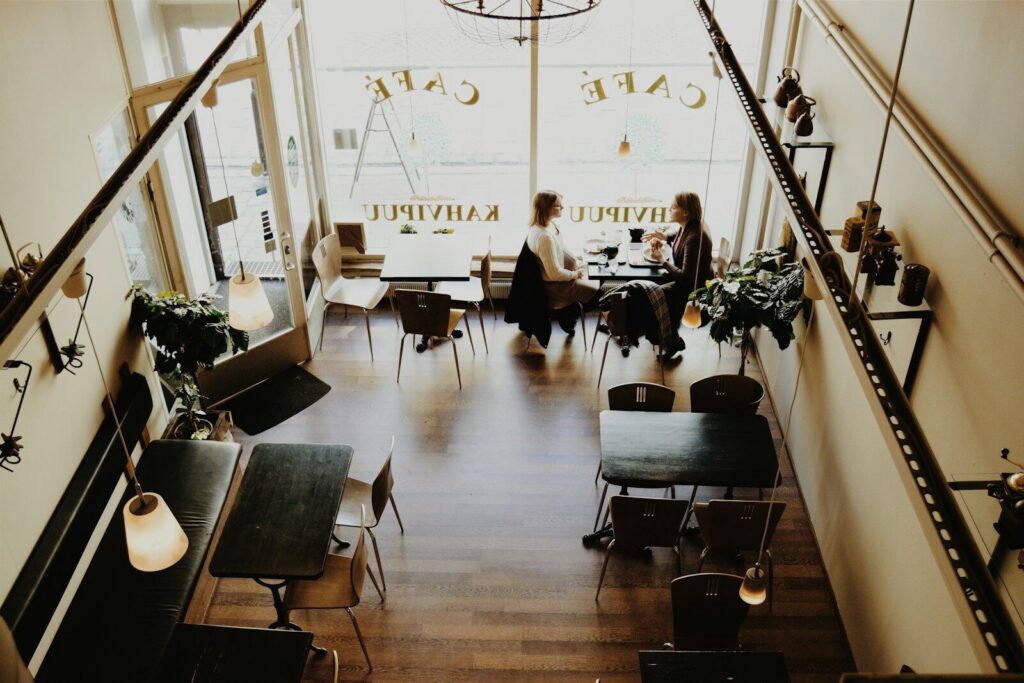 A recovery mentor meeting with a mentee in a cafe