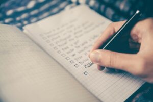 Person writing recovery goals in journal