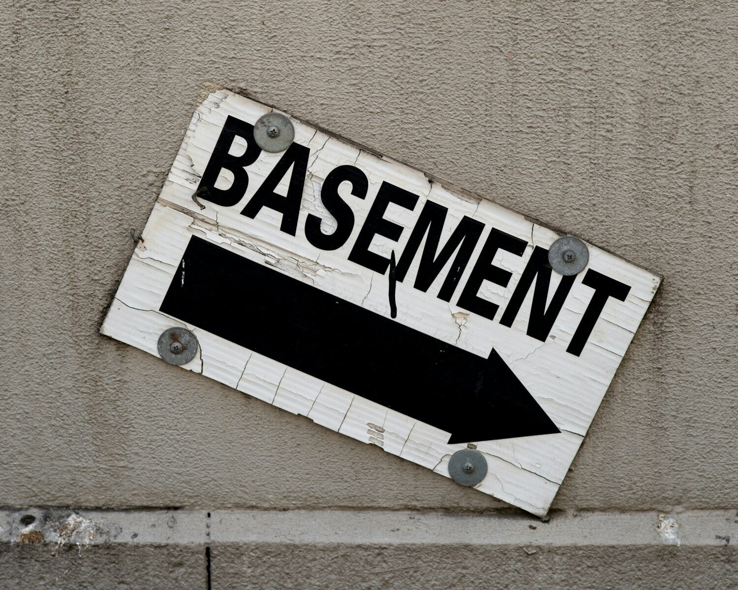 a sign on the side of a building representing a secret sexual basement