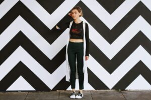 California sober woman standing beside white and black chevron wall