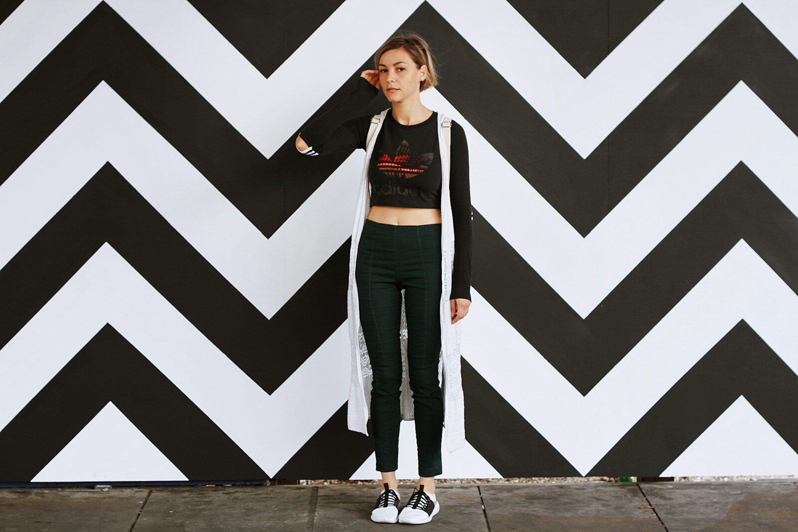 California sober woman standing beside white and black chevron wall