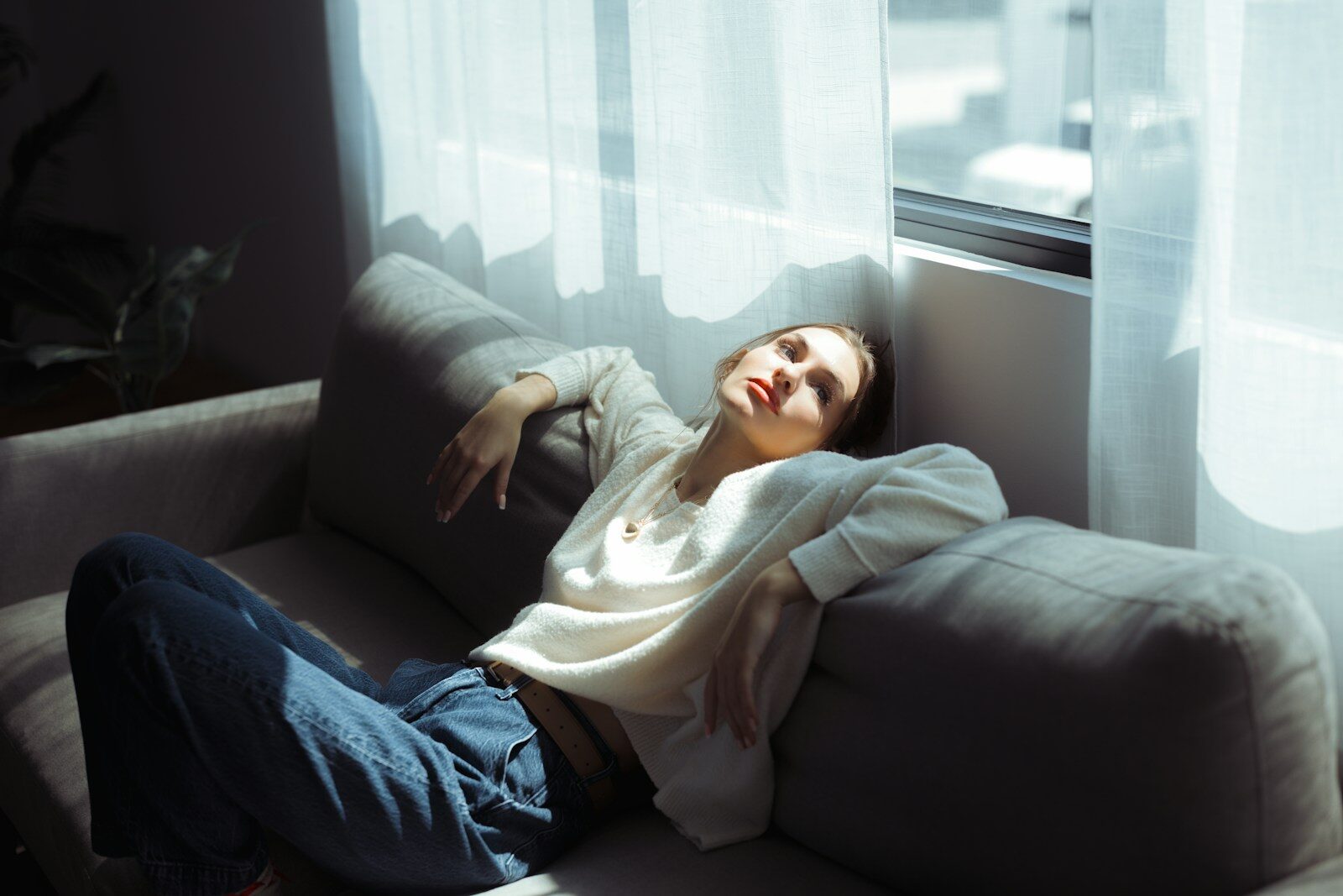 A woman in a white sweater wrestling with intrusive vs impulsive thoughts