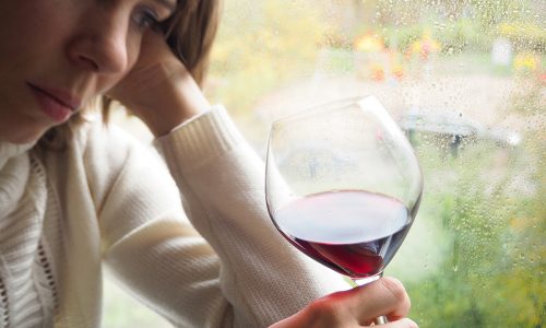 sad woman with wine experiencing alcohol and depression