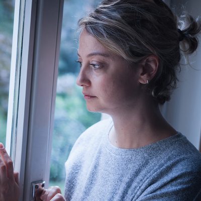 woman staring out of a window wondering am I an alcoholic